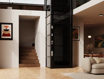 Black framed cube home elevator installed beside a staircase in an open living room